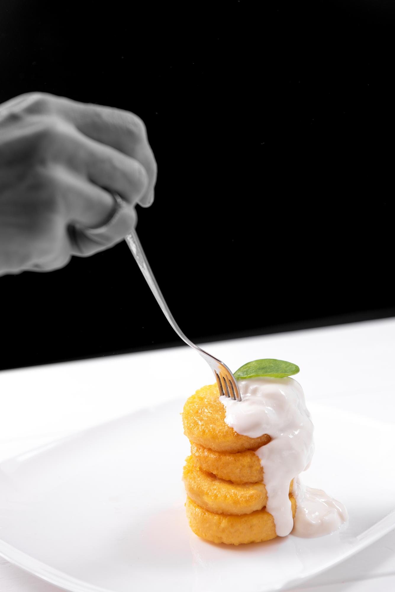 Chef arranging garnish under lamp